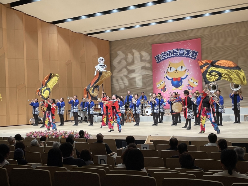 専修大学熊本玉名高校吹奏楽部、ステージで旗を振ったり、演奏をする様子の写真