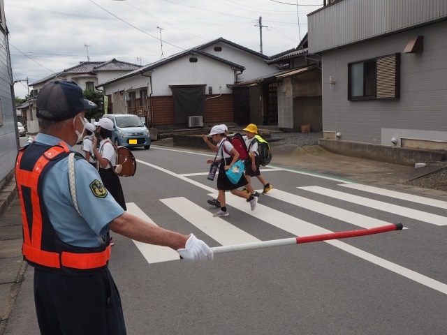 交通指導員として登校する子どもたちの見守り活動をしている岡部さんの様子の写真