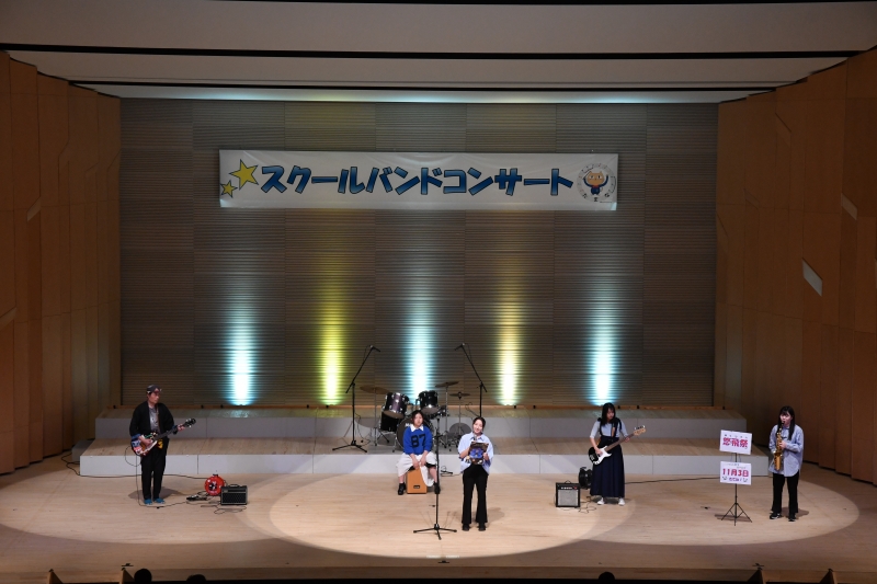 日本総合教育専門学校軽音部の演奏(後方がライトアップされている)の様子写真