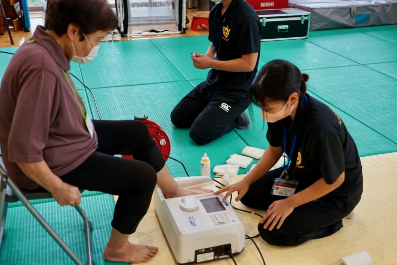 健康教室、足趾力等の測定をしている参加者の様子の写真