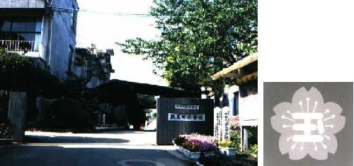 玉名町小学校校舎と校章の画像