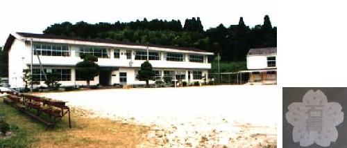 石貫小学校校舎と校章の画像