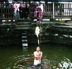 池に竿を立てる様子の画像