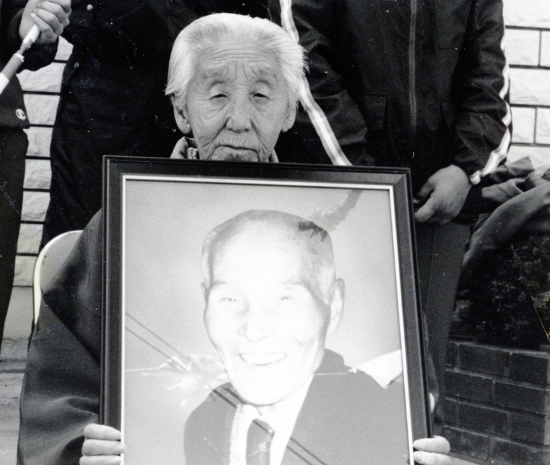昭和59年(1984)第35回金栗杯玉名30キロロードレース大会で遺影を抱くスヤさんの写真