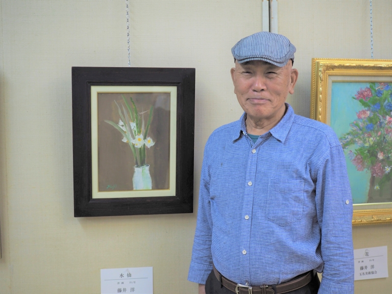 玉名美術協会小品展の水仙の絵をバックに撮影した写真