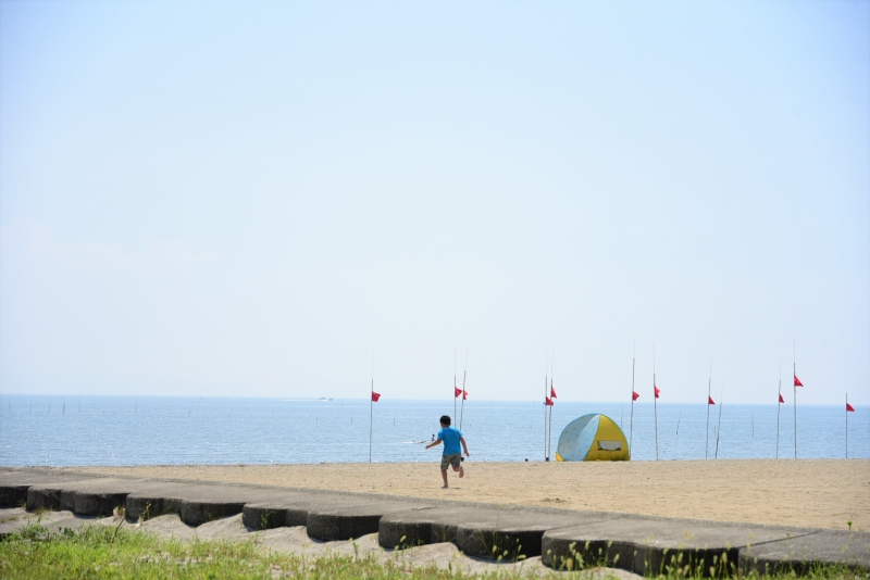 鍋松原海水浴場、黄色いテントと走っている男の子の写真