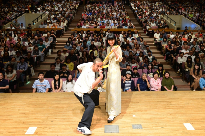 峯田和伸さんと橋本愛さんがステージ上でポーズをとっている写真