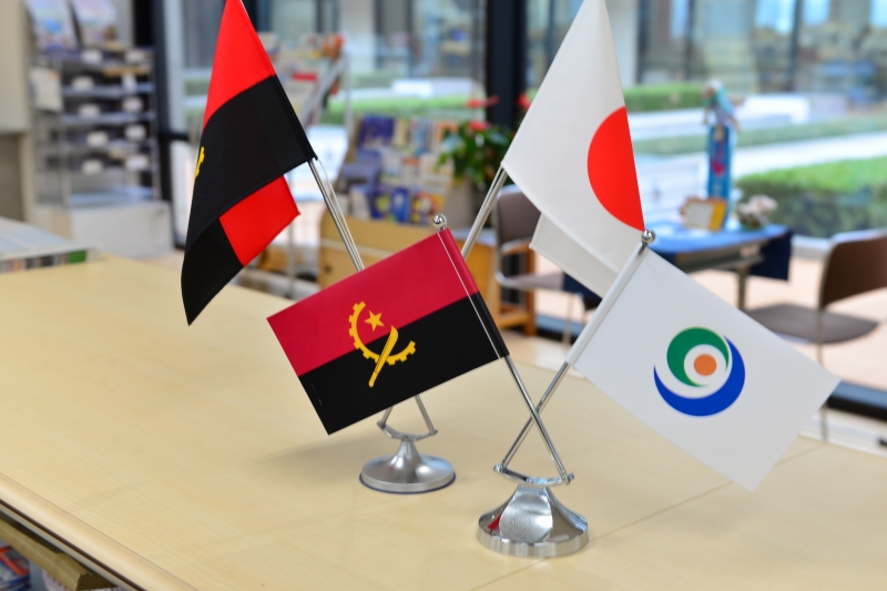 アンゴラ国旗、日本国旗、玉名市旗が並んでいる写真