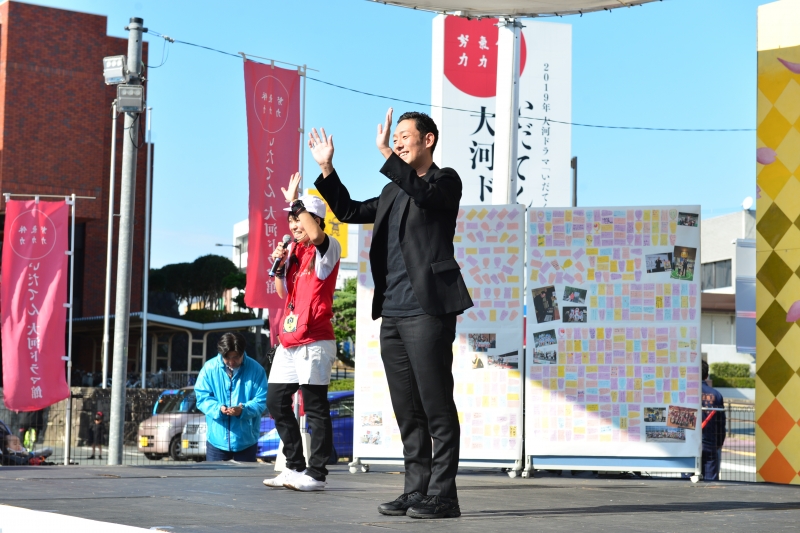 勘九郎さんがドラマ館ステージで会場から手を振っている写真