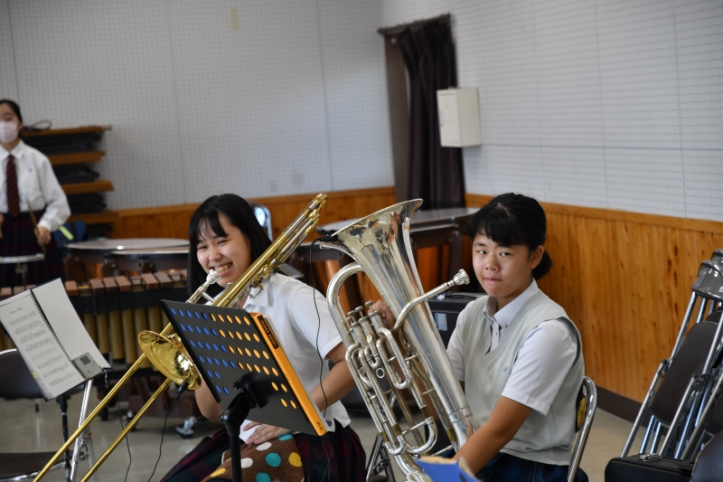 北稜&玉名工業高校の女生徒が微笑みながら演奏している写真
