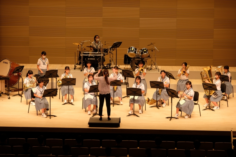 有明中学校吹奏楽部がステージで演奏している写真