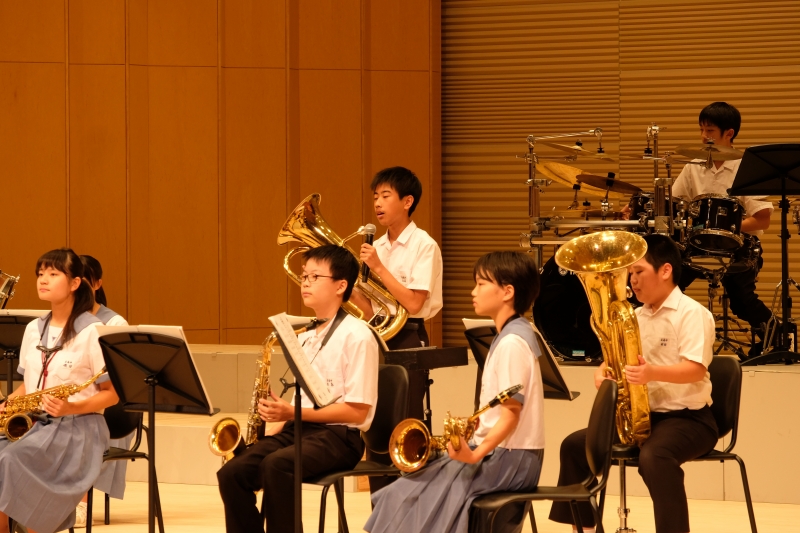 玉南中学校吹奏楽部がステージで演奏している写真
