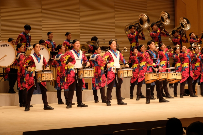 専修大学玉名高校吹奏楽部がステージで演奏演技している写真