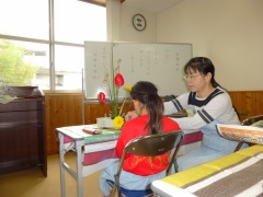 いけばな教室を体験している子供の背面からの写真です